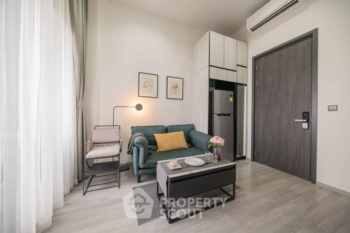 Modern living room with stylish decor and compact kitchen area in a cozy apartment.