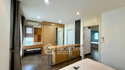 Spacious modern bedroom with wooden flooring and built-in storage