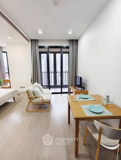 Modern living room with balcony view and dining area in open layout apartment.