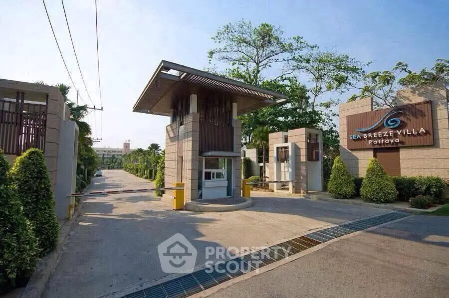 Luxurious entrance of Sea Breeze Villa with modern architecture and lush greenery.