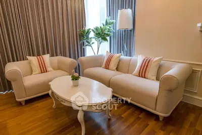 Elegant living room with plush sofas, stylish coffee table, and lush indoor plant, perfect for relaxation.