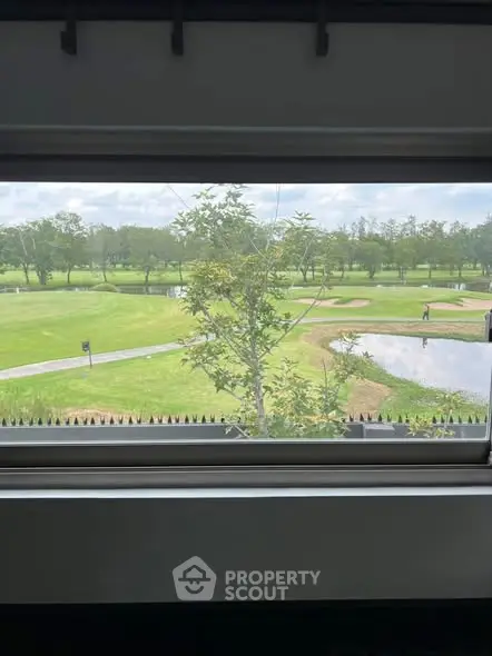 Stunning golf course view from a window, showcasing lush greenery and serene landscape.