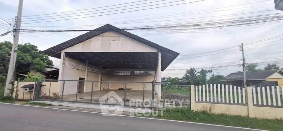 Spacious warehouse with open layout and secure fencing in a serene neighborhood.