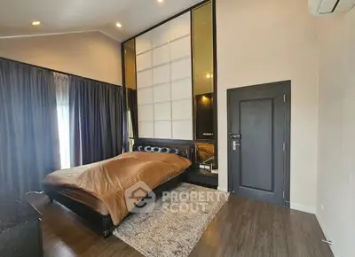 Modern bedroom with stylish decor and large bed, featuring elegant lighting and floor-to-ceiling curtains.
