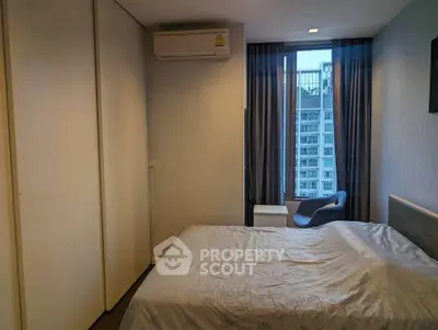 Modern bedroom with city view, featuring sleek design and ample natural light.