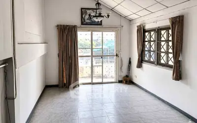 Spacious living room with large windows and balcony access, perfect for natural light and fresh air.