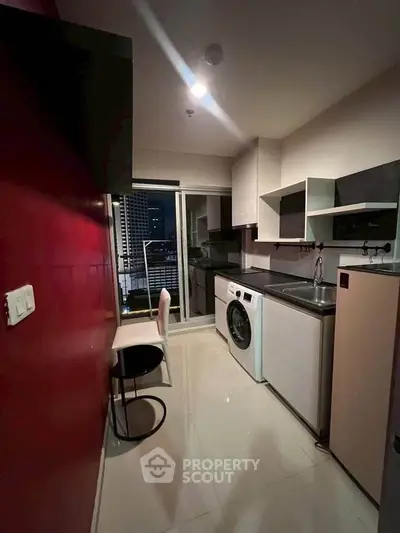 Modern kitchen with washing machine and city view from balcony