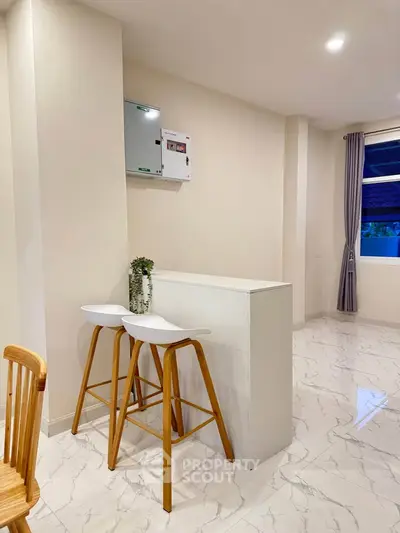 Modern interior with sleek bar stools and marble flooring in a stylish living space.