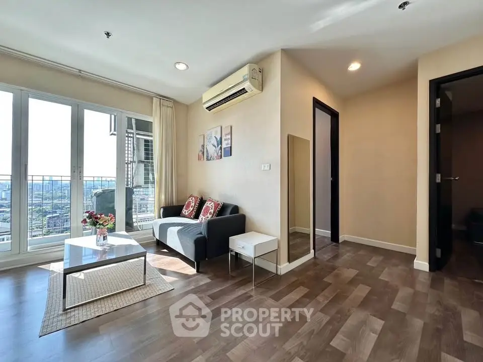 Modern living room with city view, featuring sleek furniture and natural light.