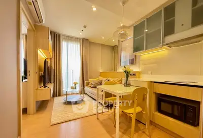 Modern living room with open kitchen, featuring stylish furniture and natural light.