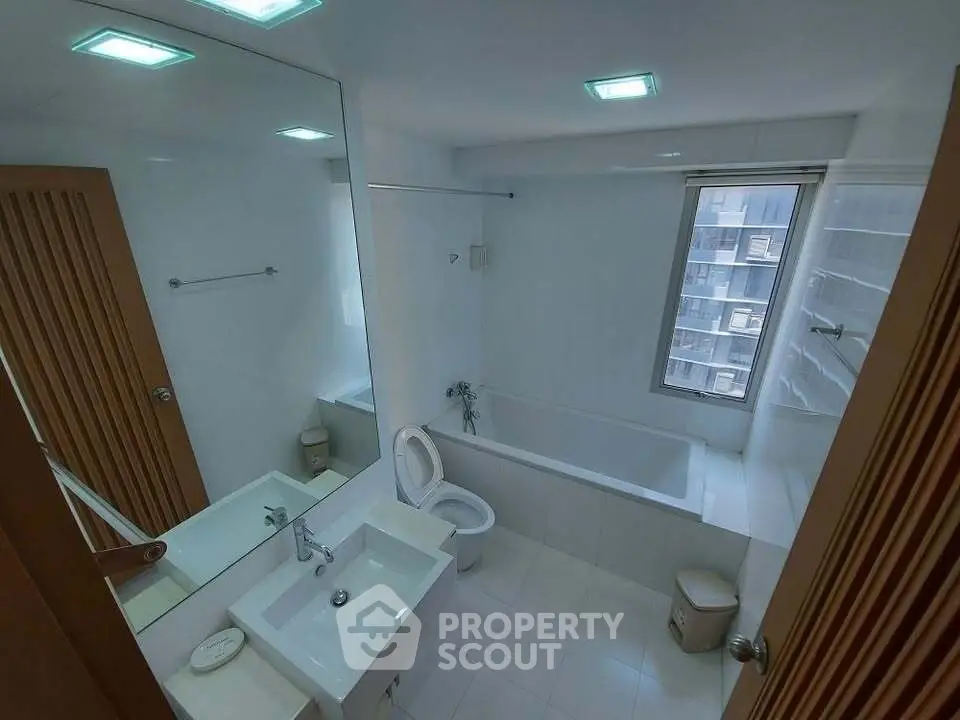 Modern bathroom with bathtub and large mirror in a high-rise apartment