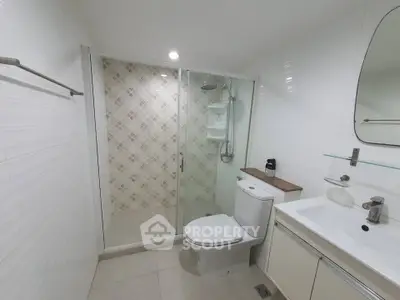 Modern bathroom with glass shower and sleek fixtures in a contemporary home.