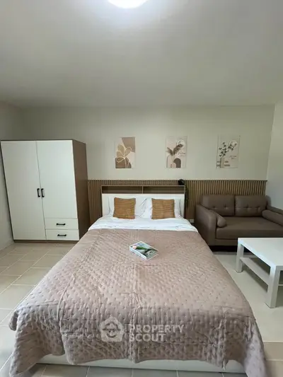 Cozy bedroom with stylish decor, featuring a comfortable bed, modern wardrobe, and elegant artwork.