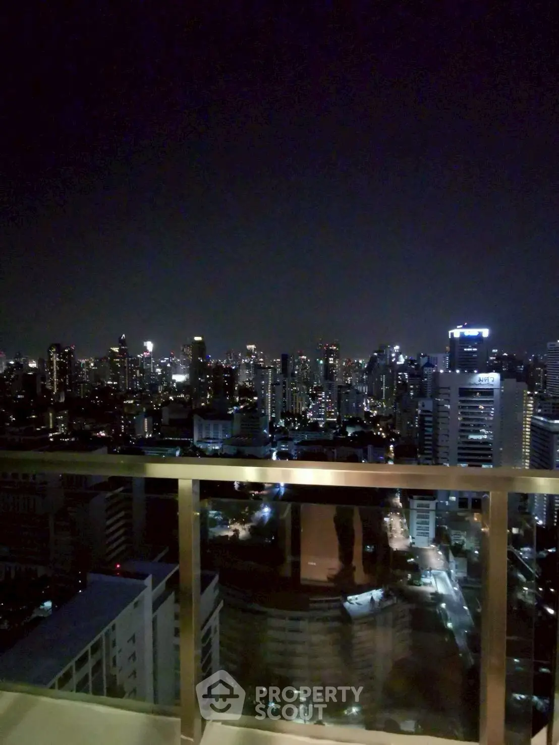 Stunning city skyline view from a high-rise balcony at night, perfect for urban living enthusiasts.