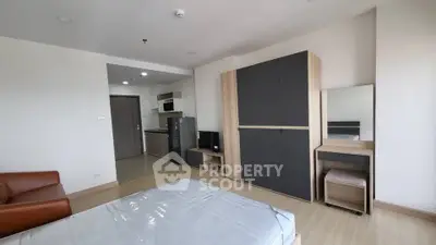 Modern studio apartment with sleek furniture and compact kitchen