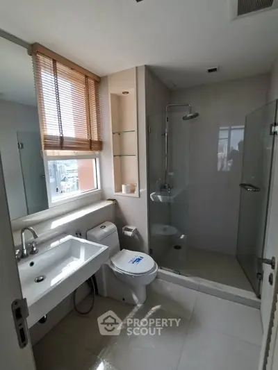 Modern bathroom with glass shower and city view window