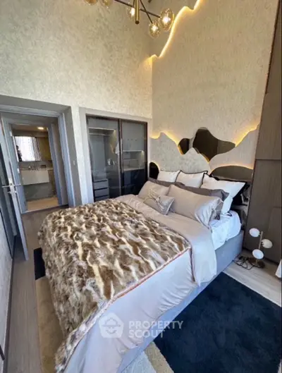 Luxurious bedroom with modern decor and unique wall design, featuring a plush bed and stylish lighting.