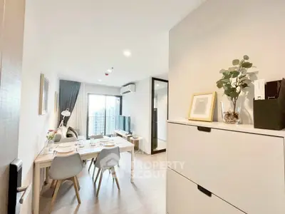 Modern open-plan living and dining area with stylish decor and city view.