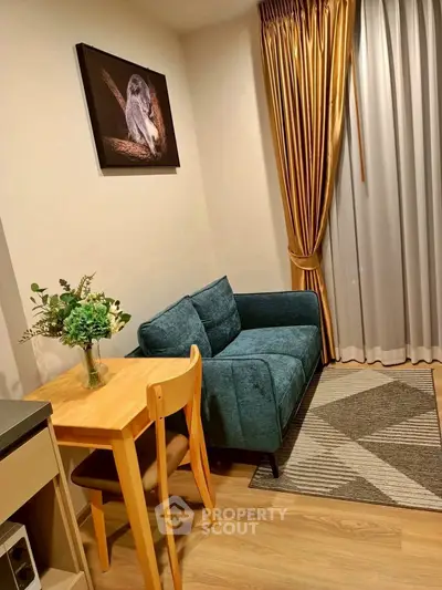 Cozy living room with teal sofa, wooden table, and elegant curtains in modern apartment.