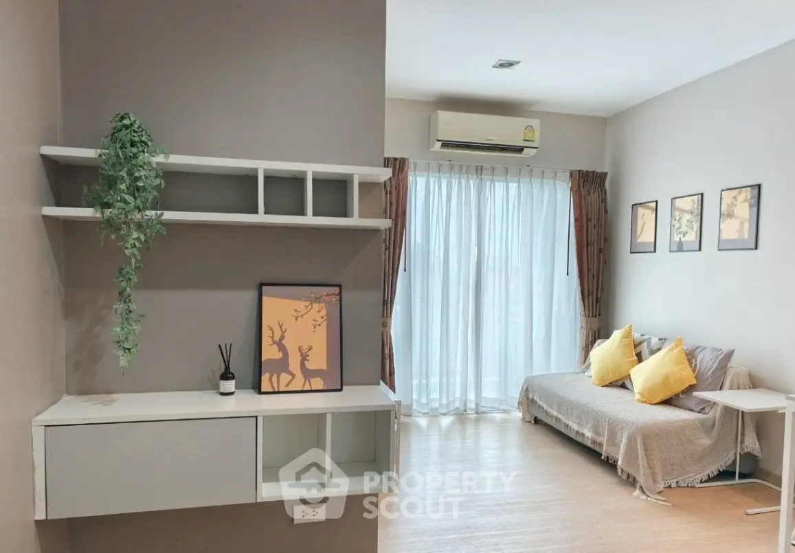 Cozy living room with natural light, modern decor, and comfortable seating.