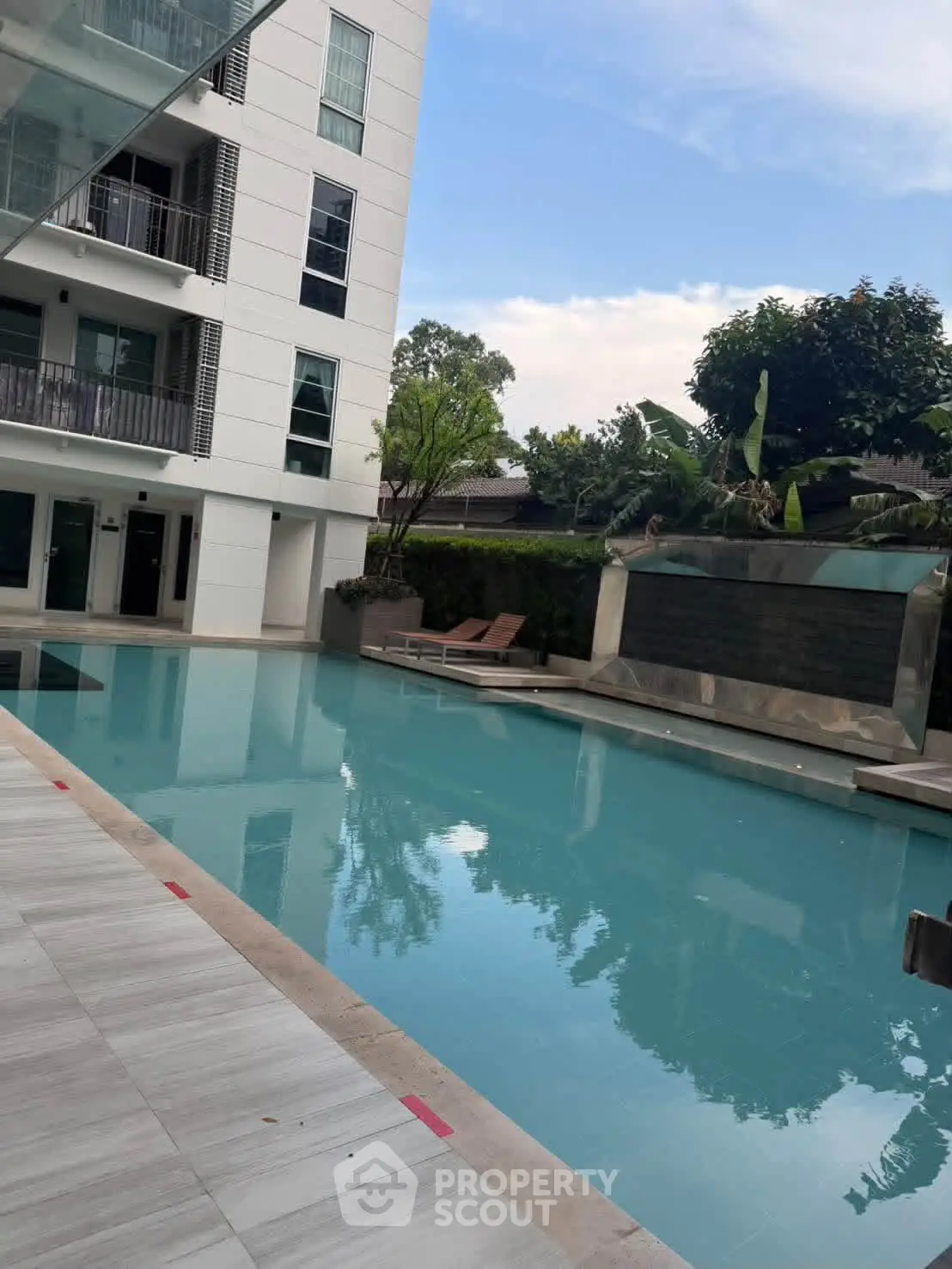 Luxurious apartment complex with stunning pool and modern architecture.