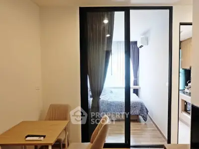 Modern apartment interior with cozy bedroom and dining area, featuring sleek sliding glass doors and natural light.