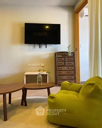 Cozy living room with modern TV setup and stylish furniture, perfect for relaxation.