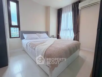 Cozy bedroom with large windows and modern decor in a stylish apartment.