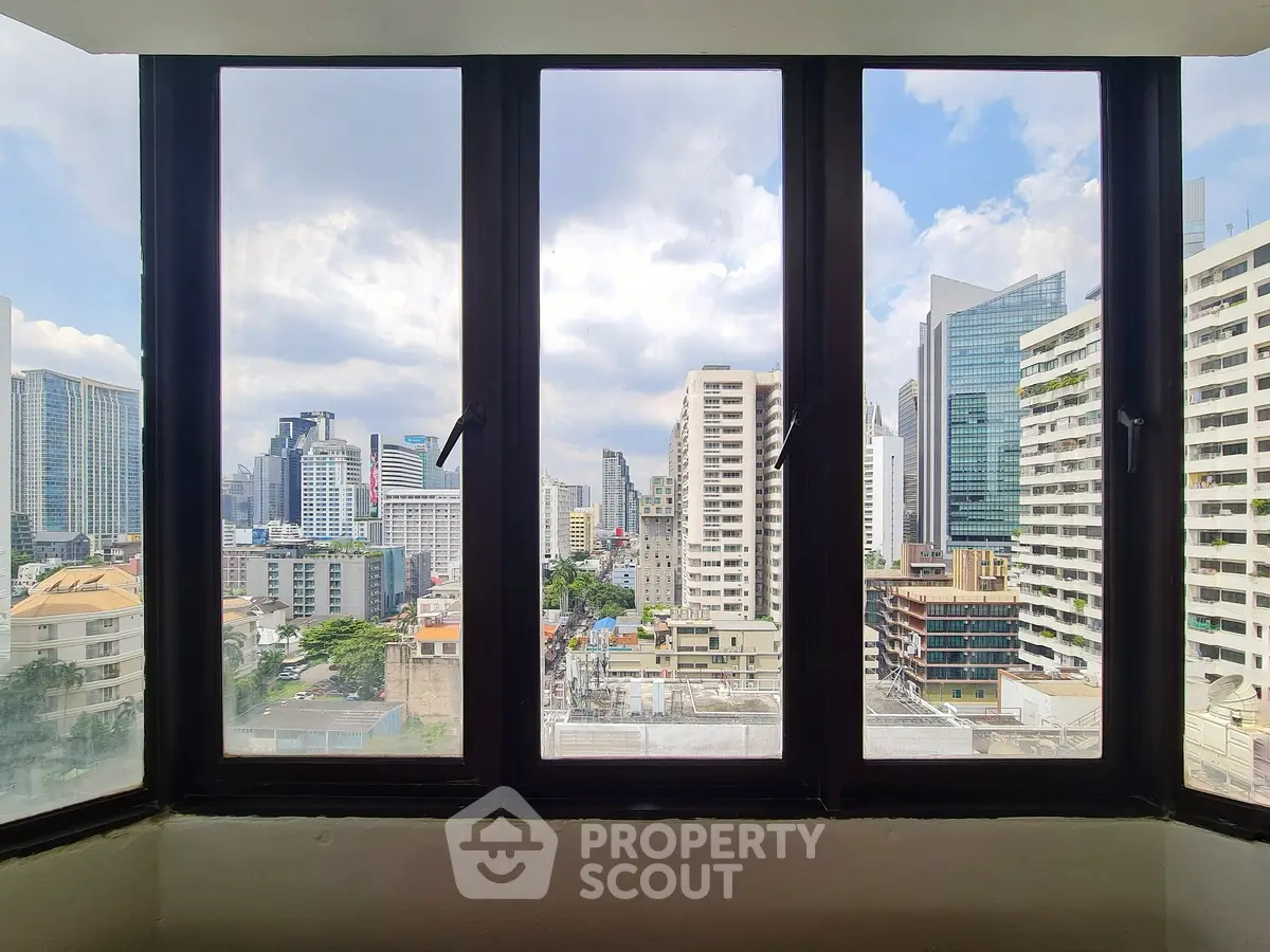 Stunning cityscape view from a high-rise window, showcasing modern skyscrapers and urban skyline.