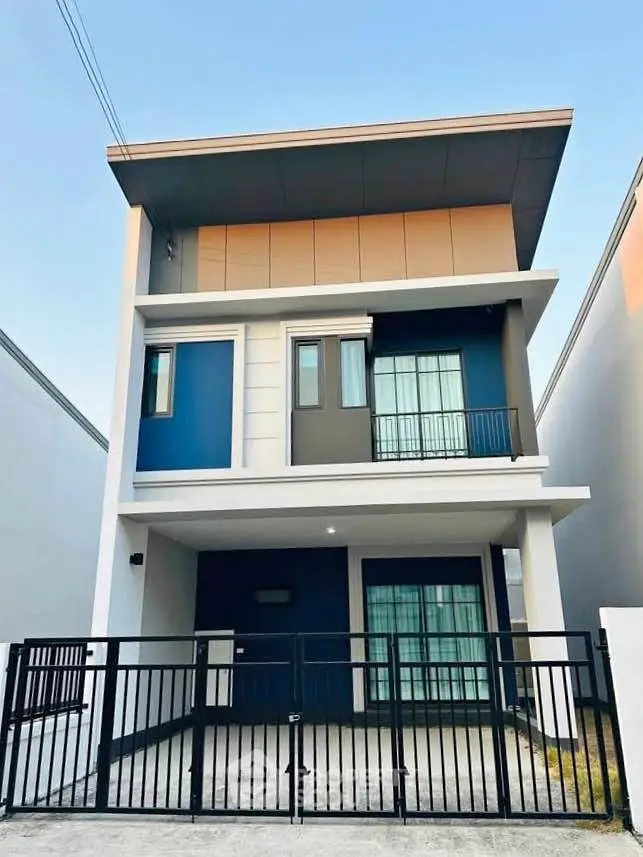 Modern three-story house with sleek design and gated entrance, perfect for urban living.