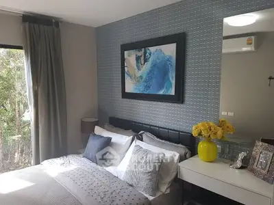 Chic bedroom with modern decor, stylish artwork, and lush greenery view.