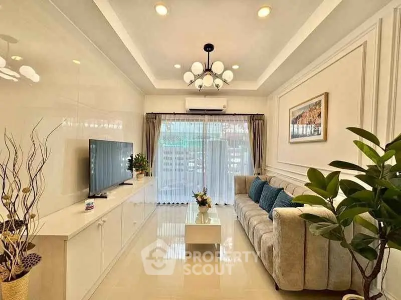 Elegant living room with modern decor, plush sofa, and large TV, perfect for relaxation and entertainment.
