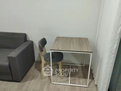 Modern minimalist living room with sleek sofa and compact study desk, perfect for urban living.