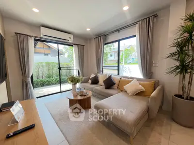 Modern living room with large windows, cozy sectional sofa, and stylish decor in a bright, airy space.