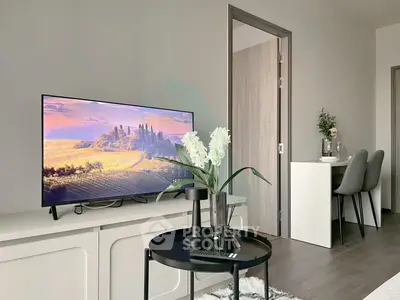 Modern living room with stylish decor and flat-screen TV, perfect for relaxation and entertainment.