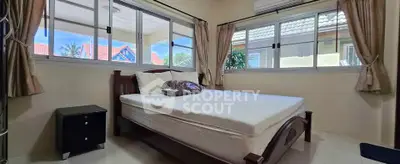 Cozy bedroom with large windows and natural light in a charming home.