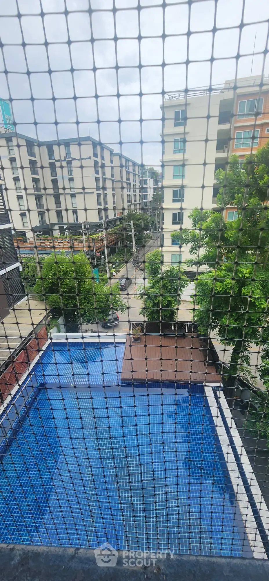 Modern urban apartment view with pool and lush greenery, perfect for city living.
