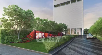 Modern building exterior with lush landscaping and sleek driveway entrance
