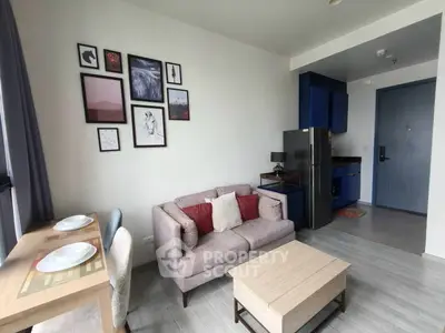 Modern living room with stylish decor and compact kitchen in open layout apartment.