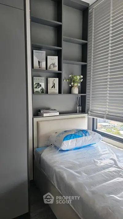 Modern bedroom with sleek shelving and large window offering natural light.