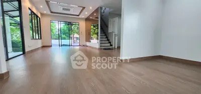 Spacious modern living room with large windows and wooden flooring