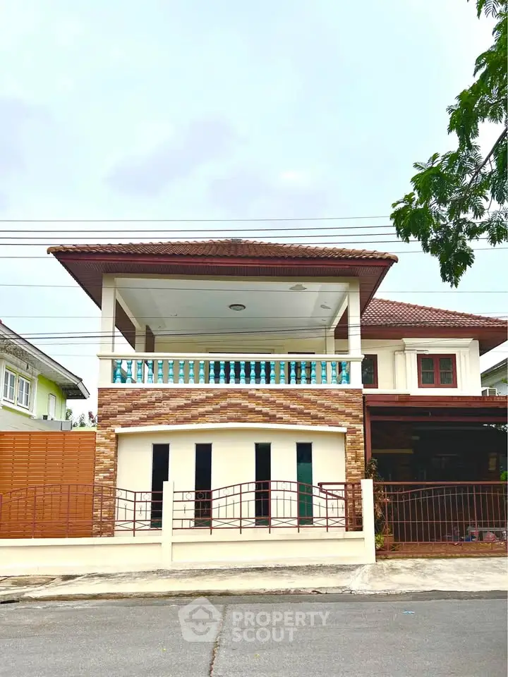 Charming two-story house with spacious balcony and modern facade in a serene neighborhood.