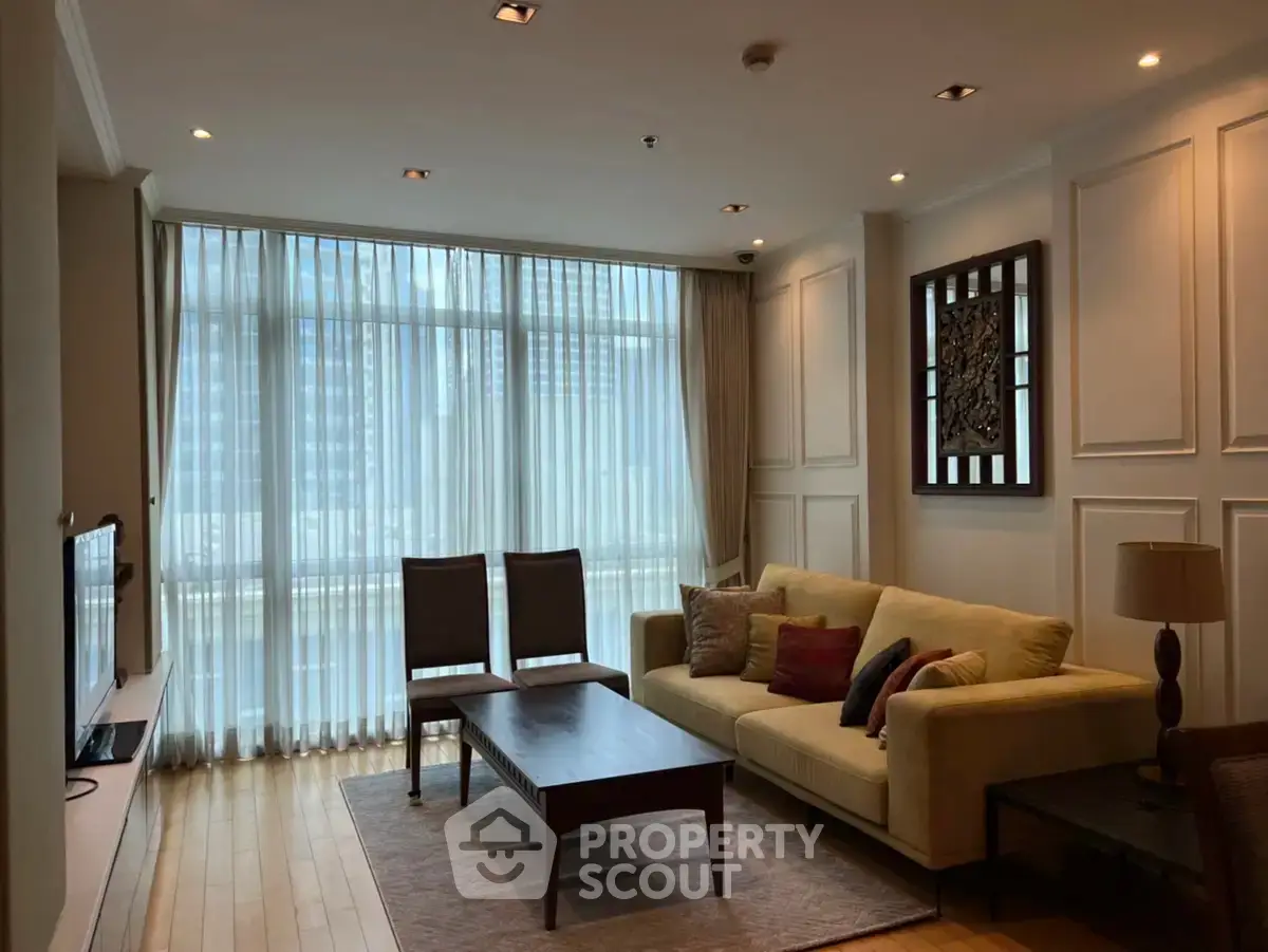 Elegant living room with large windows and stylish decor in a modern apartment.