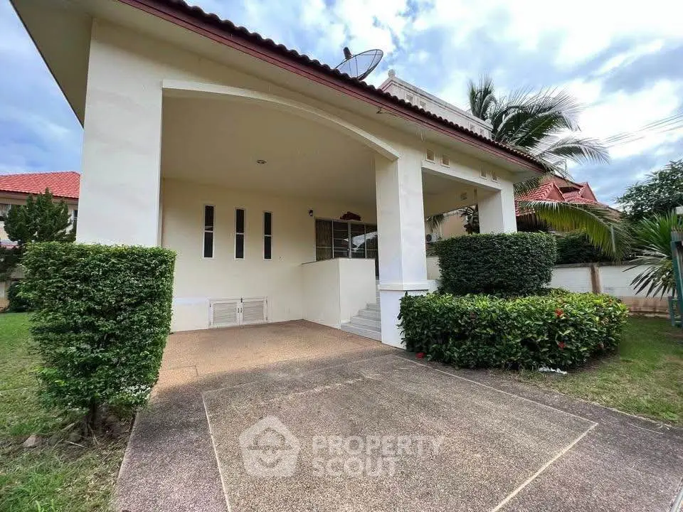 Charming suburban home with lush greenery and spacious driveway, perfect for family living.