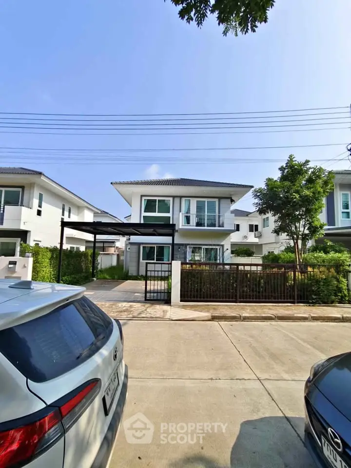 Modern two-story house with driveway and garden in suburban neighborhood