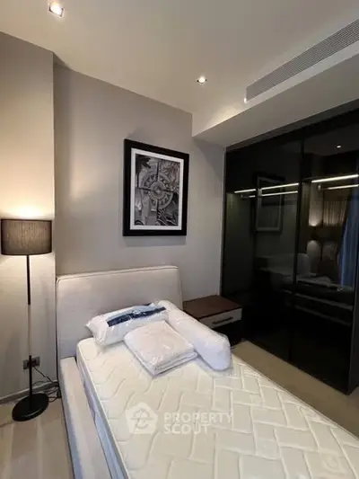 Modern bedroom with stylish decor and sleek glass wardrobe