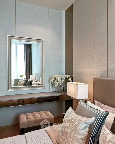 Luxurious bedroom with elegant decor and large mirror reflecting natural light.