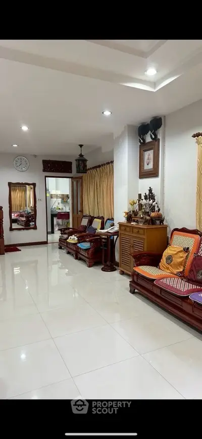 Spacious living room with elegant wooden furniture and bright lighting.