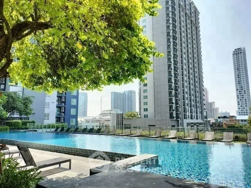 Luxurious urban apartment complex with stunning poolside view and modern high-rise buildings.