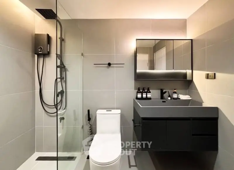 Modern bathroom with sleek fixtures and glass shower enclosure.